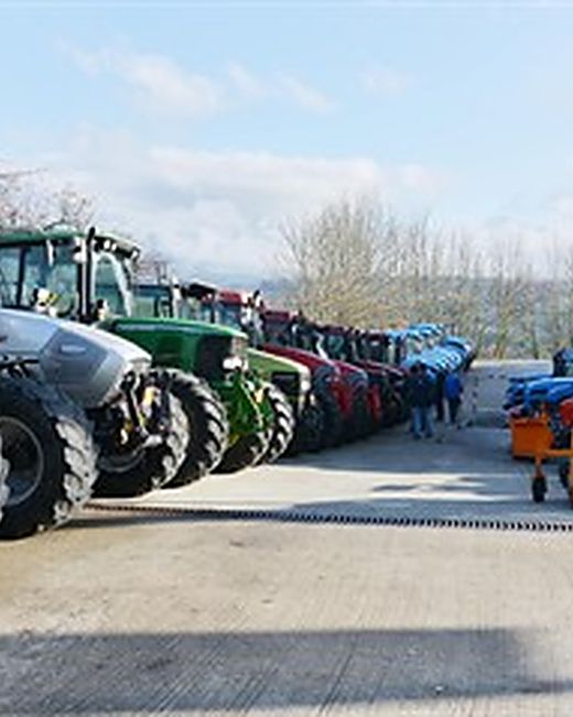 Tracteurs alignés dans la cour avant une exposition